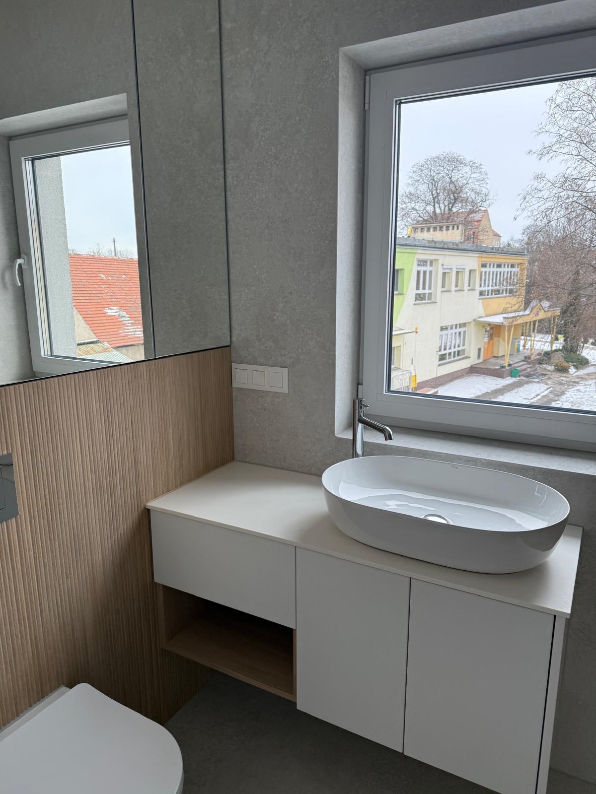 Podwieszana szafka z umywalką nablatową i otwartą półką.