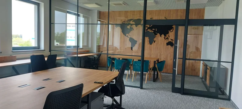 A coherent composition of desks, a meeting table and storage units.