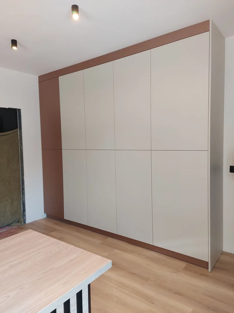 Tall cabinetry with light fronts and frames in a warm, subdued shade.