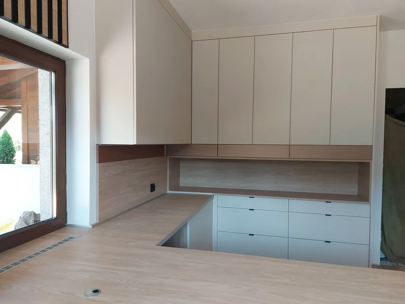 An open recess above the countertop and subtle handles on the lower drawers.