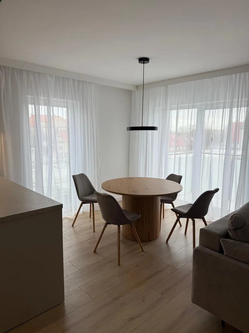 A round table on a grooved base in a bright living area.