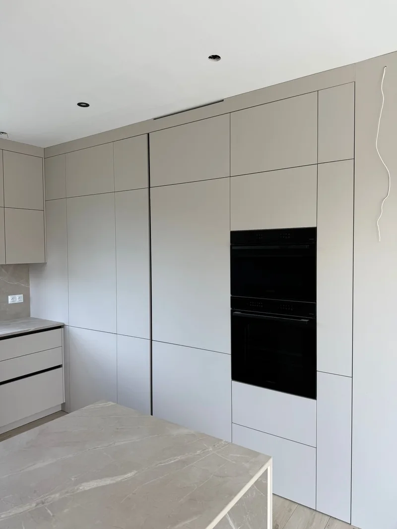 Black devices integrated into tall cabinetry.