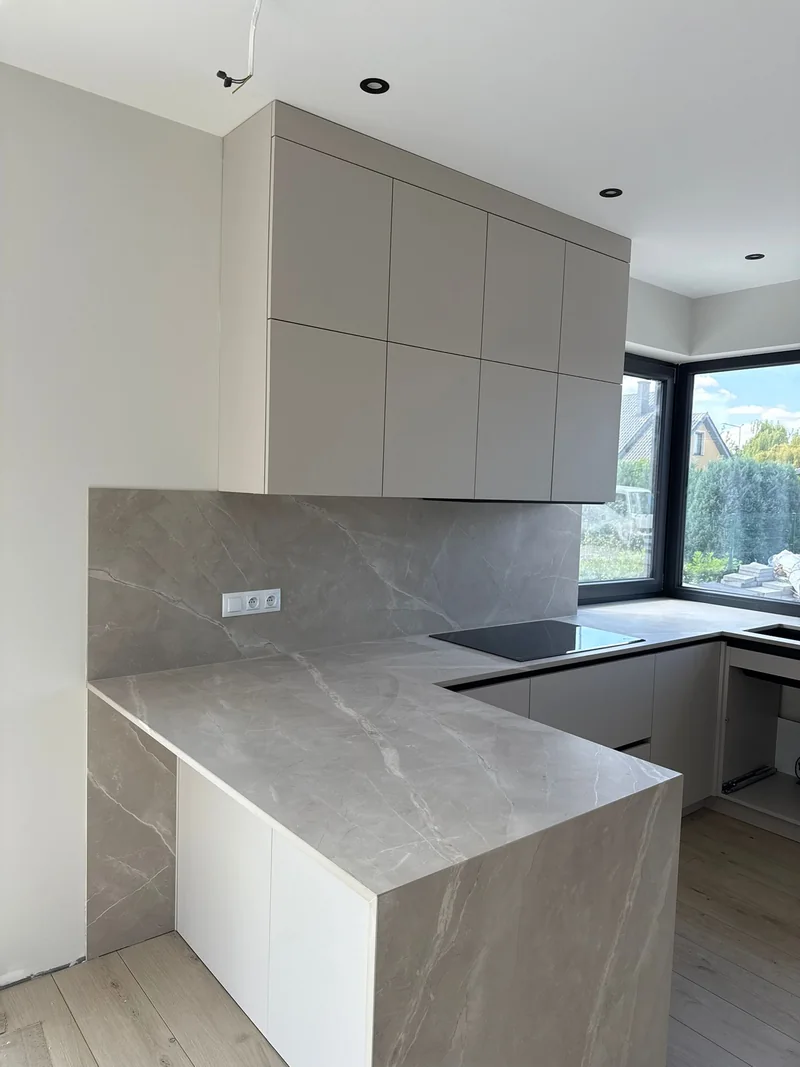 The countertop decor extends to the side of the peninsula, creating a consistent finish.
