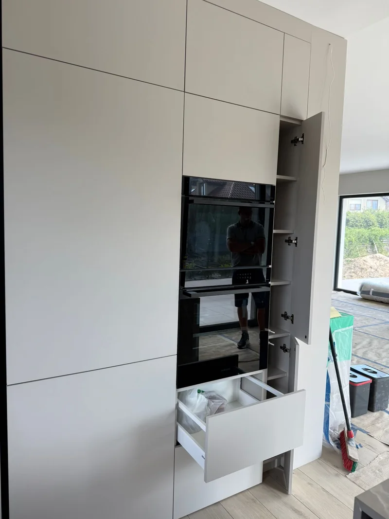 Tall cabinetry with devices, a narrow cabinet and a spacious drawer.
