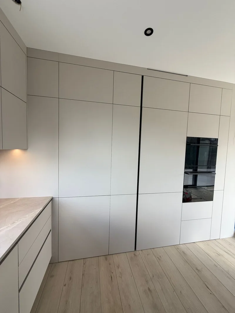 A uniform composition of light-coloured cabinet doors with black accents.