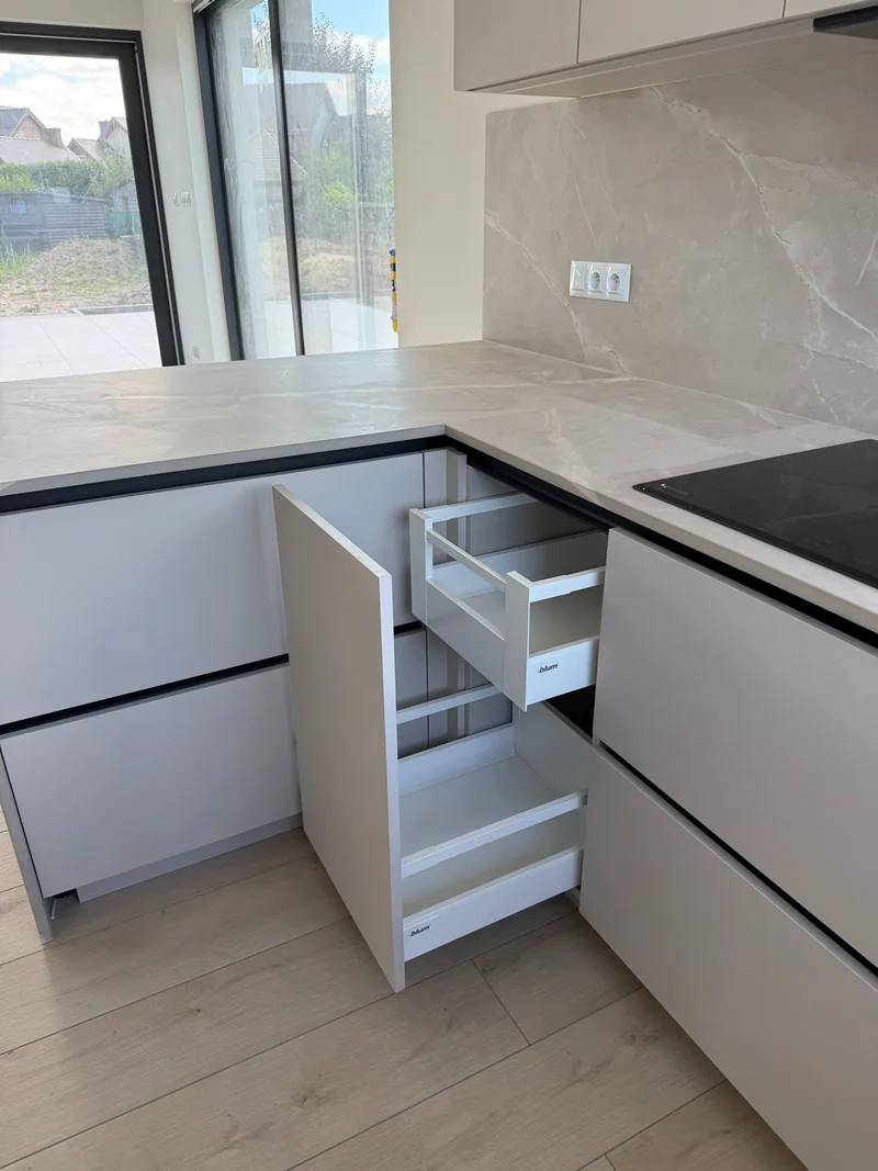 Pull-out baskets facilitate access to the contents of a narrow cabinet.