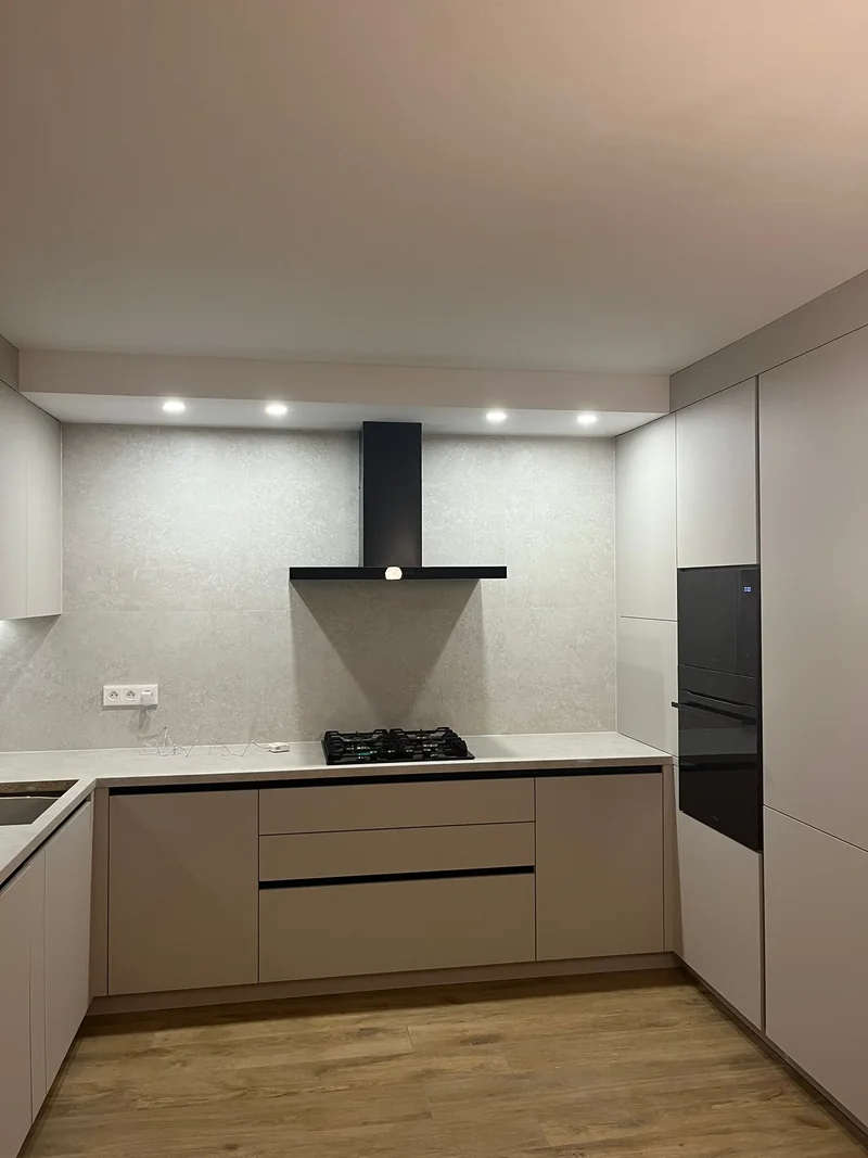Cooking zone with wide drawers and black hood.
