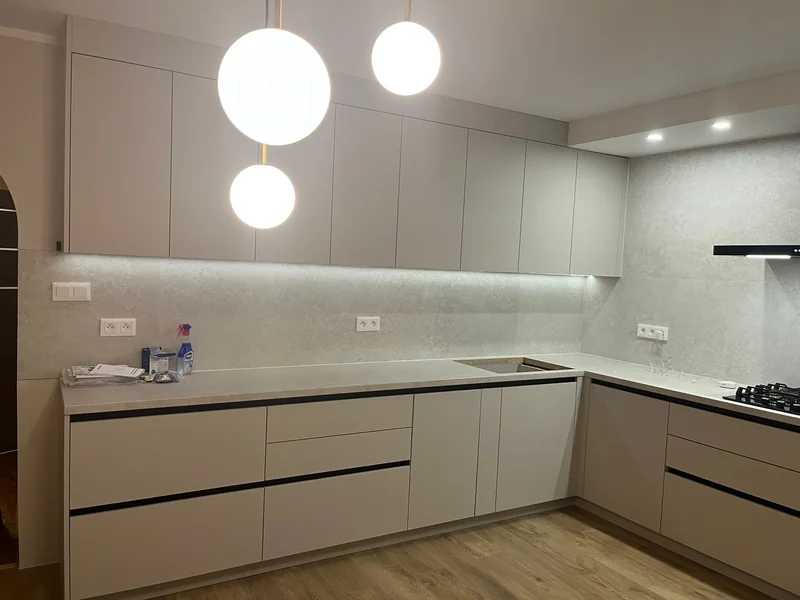 Spherical lamps above the countertop and a uniform line of upper cabinets.