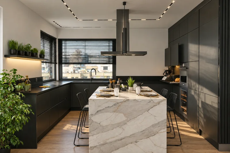 A bright island with a place for shared meals against the background of graphite cabinetry.
