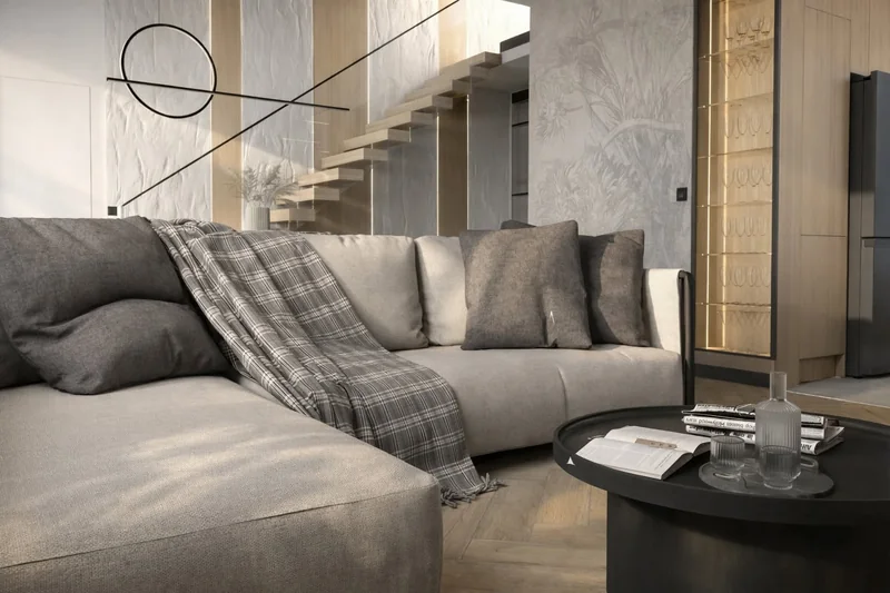 Soft fabrics, a black table and an illuminated display cabinet by the stairs.